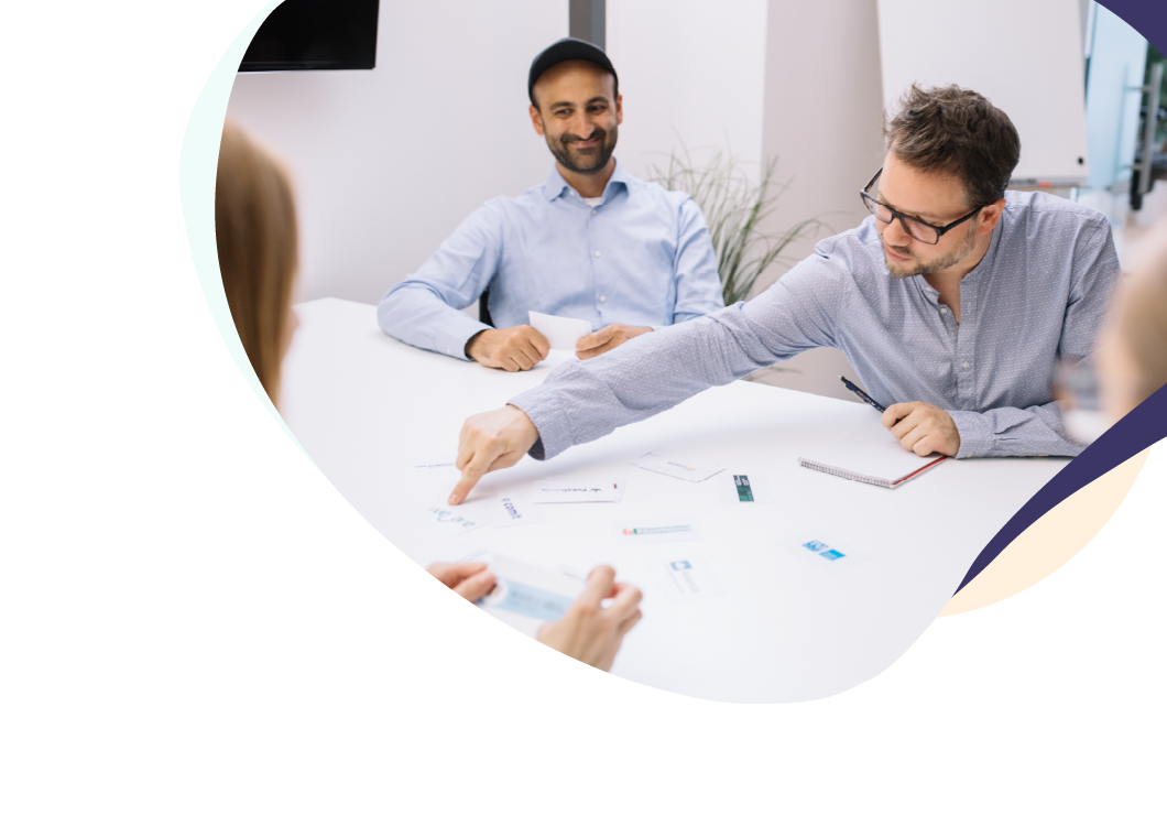 Neu_Zeichenfläche 1 mehrere Personen am Tisch mit Unterlagen, Besprechung – Business-Meeting oder Strategieentwicklung.